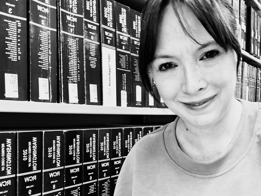 Liz Steen beside volumes of the Revised Code of Washington